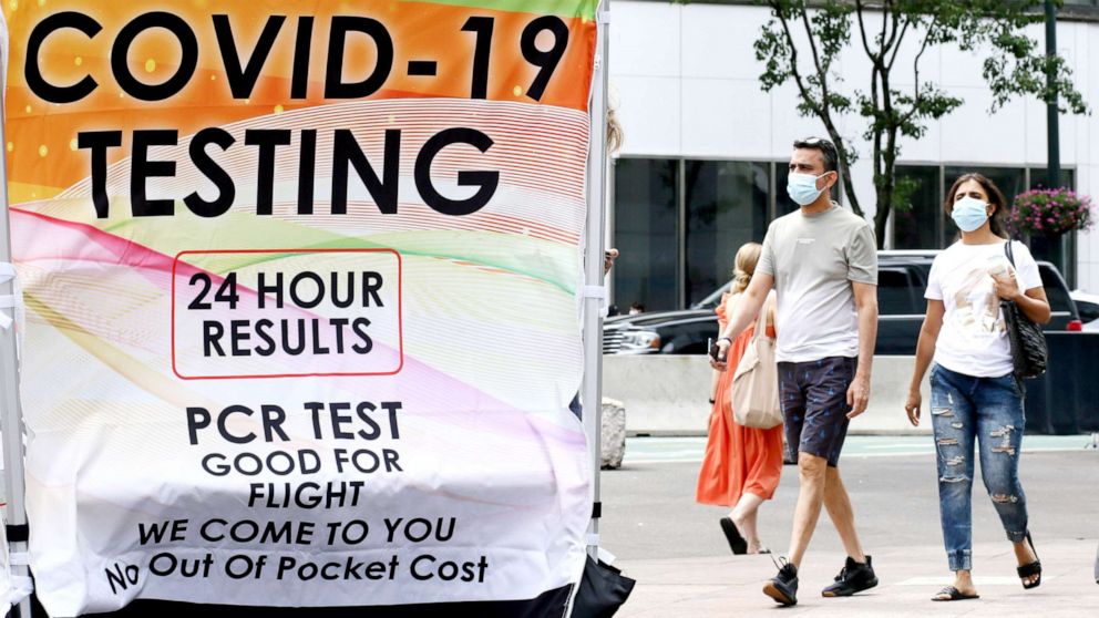 PHOTO: People wear masks near a COVID-19 walk-up testing site, on June 6, 2022 in New York City.