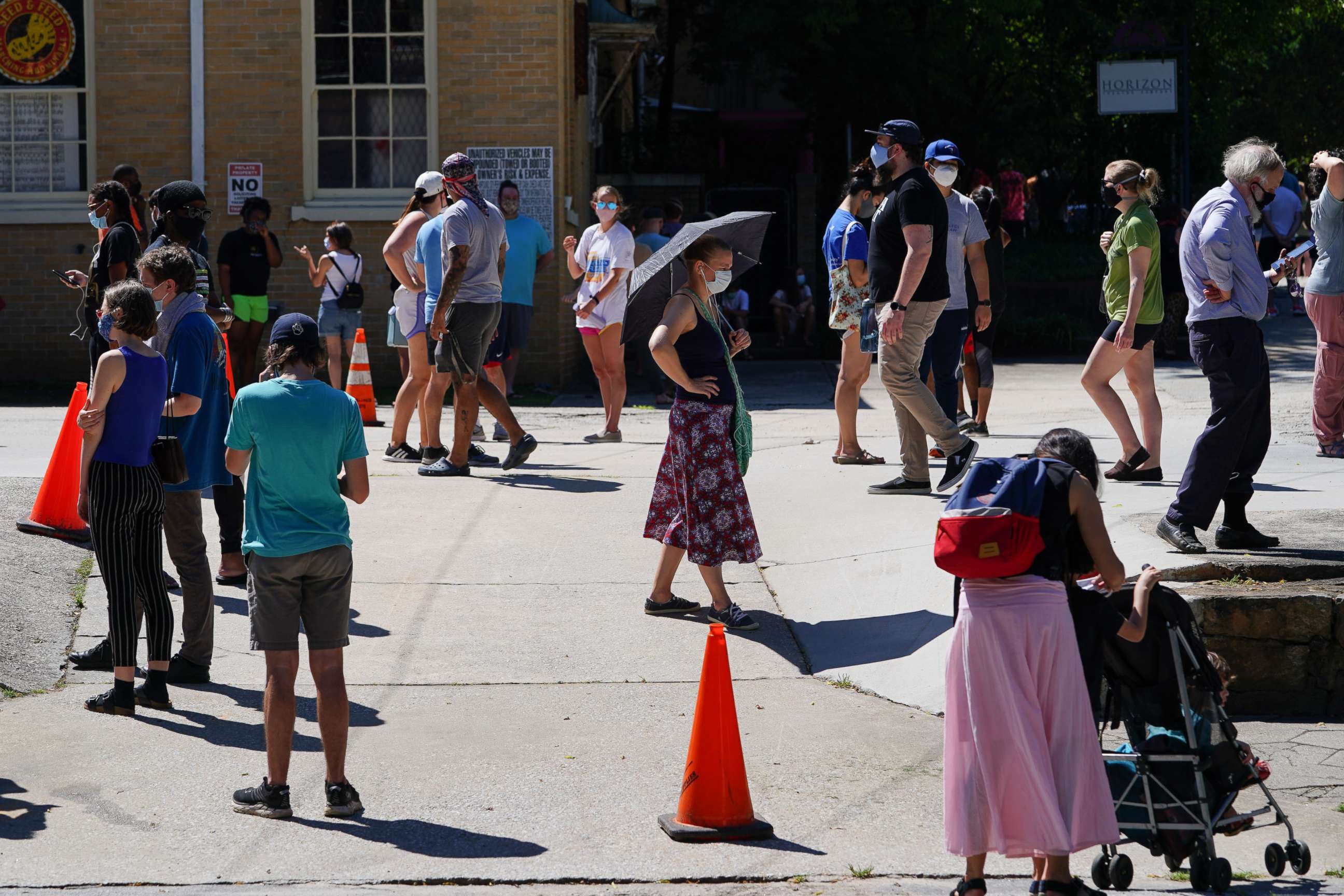 PHOTO: People stand in line to get tested for COVID-19 at a free walk-up testing site on July 11, 2020, in Atlanta.