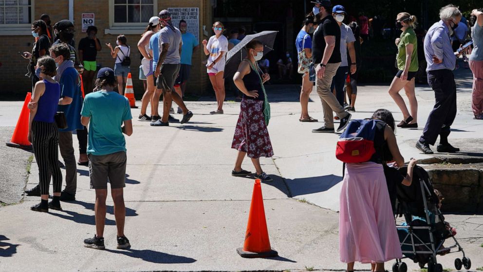 PHOTO: People stand in line to get tested for COVID-19 at a free walk-up testing site on July 11, 2020, in Atlanta.