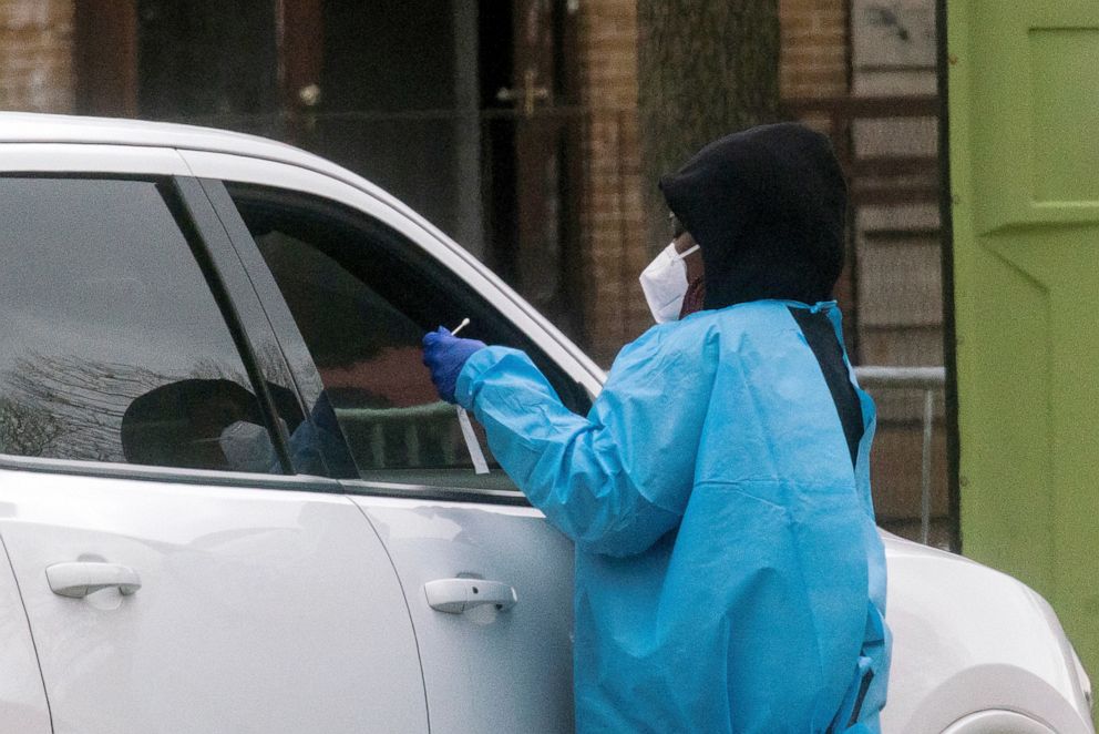 PHOTO: A health worker does a coronavirus disease (COVID-19) test as people wait at a drive-through COVID-19 testing center in a local street, in Newark, New Jersey, April 2, 2021.