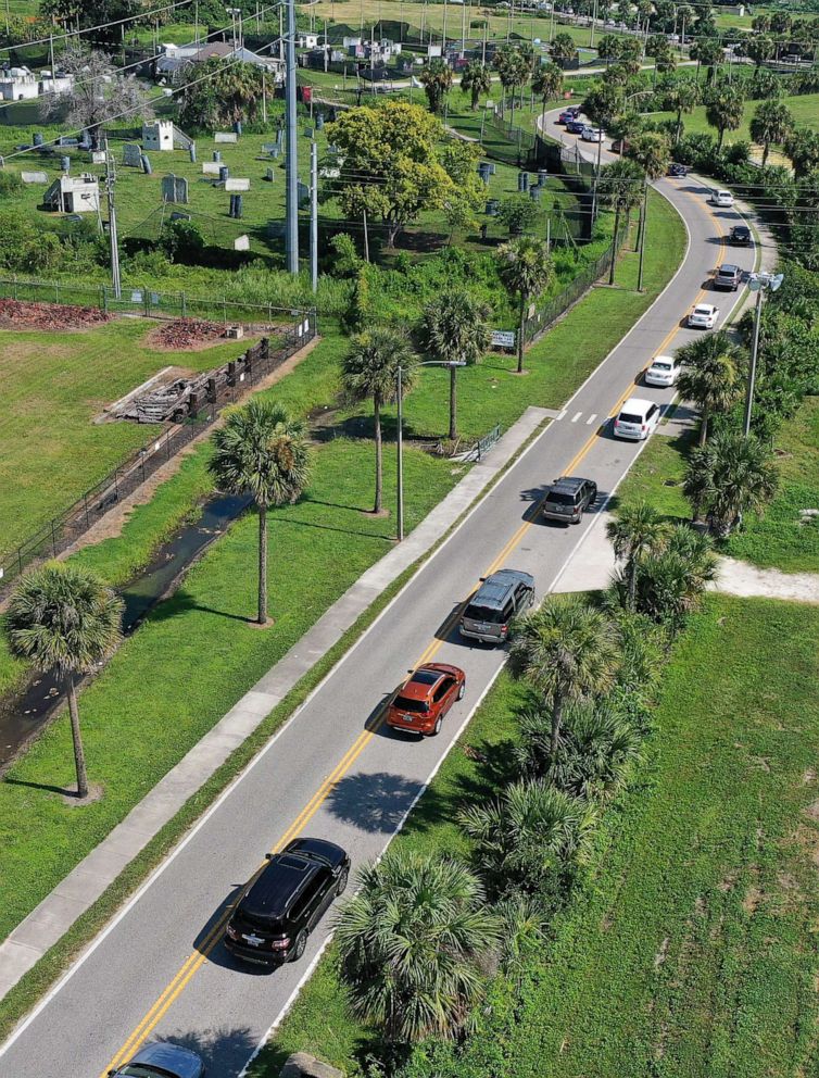 PHOTO: Vehicles line up at a drive-thru COVID-19 testing and vaccination site at Barnett Park in Orlando, July 27, 2021.