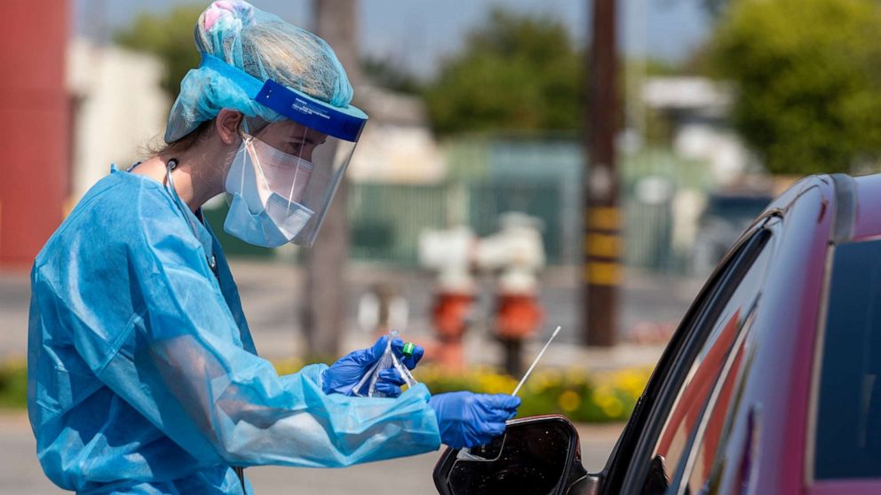 PHOTO: A physician assistant with AltaMed Health Services prepares to test a drive-through patient for COVID-19 at their Bristol Street clinic in Santa Ana, Calif. on April 21, 2020.