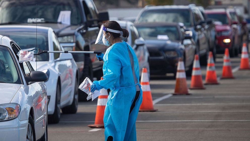 PHOTO: A health care worker conducts testing at the drive-through self-administered COVID-19 testing super site at the Orange County Fair & Events Center, Nov. 12, 2020, in Costa Mesa, Calif.