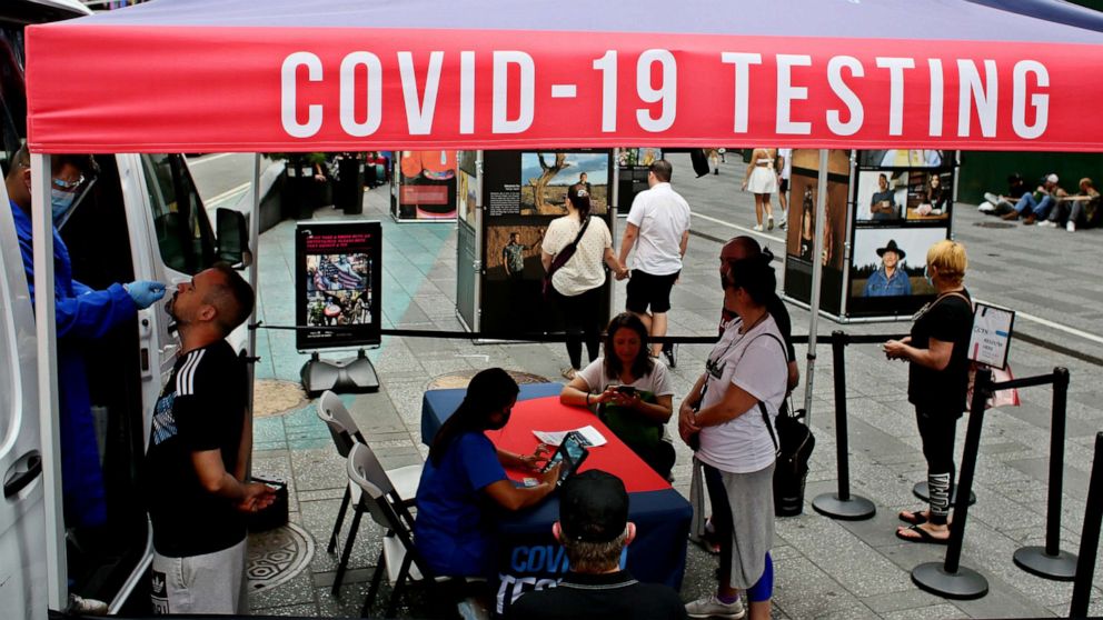 PHOTO: In this June 6, 2022, file photo, a man is tested at a COVID-19 testing van as persons wait in Times Square in New York.