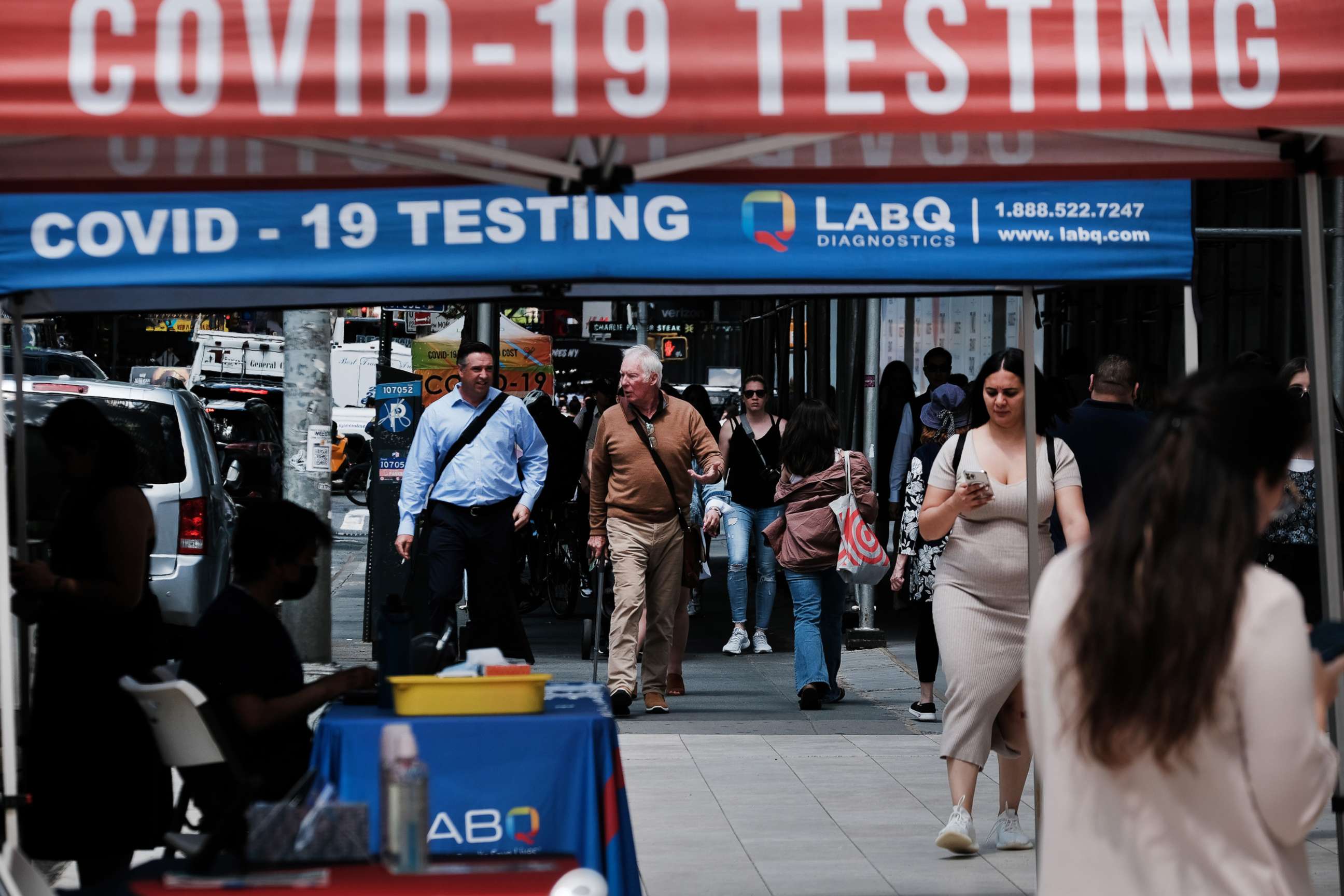 PHOTO: People walk past a COVID-19 testing site on May 17, 2022 in New York City.