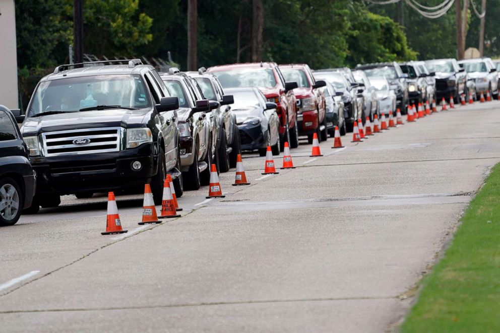 PHOTO: People wait inside their vehicles in line at COVID-19 testing site July 8, 2020, in Houston.