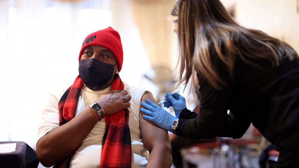 PHOTO: Dennis Simmons receives his booster vaccine shot from nurse Mariel Miagusko during a COVID-19 vaccination event in Chatham, Ill. , Dec. 30, 2021.