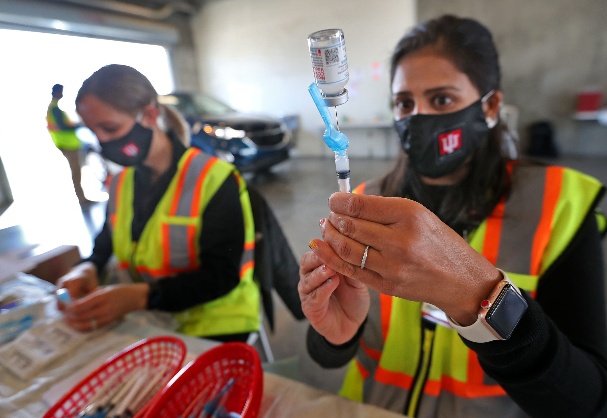 PHOTO: From left, Christy Kaminski, RN, and Pharmacist Punam Lively, get medicine ready for vaccinations in the garages for people to get vaccinated on April 13, 2021, at the Indianapolis Motor Speedway.
