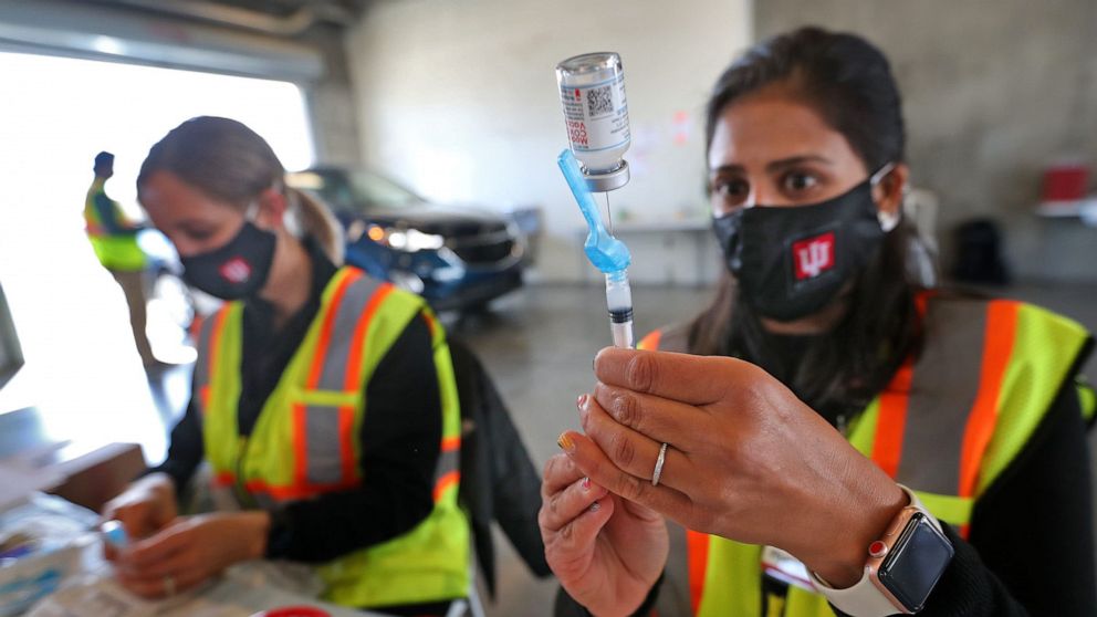 PHOTO: From left, Christy Kaminski, RN, and Pharmacist Punam Lively, get medicine ready for vaccinations in the garages for people to get vaccinated on April 13, 2021, at the Indianapolis Motor Speedway.