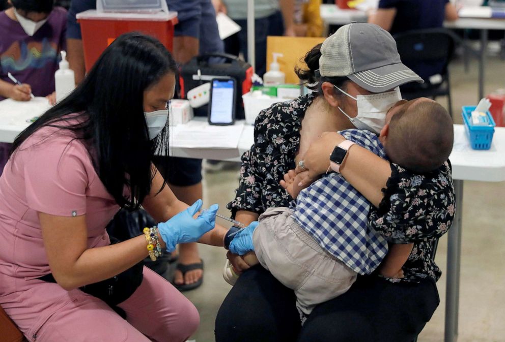 PHOTO: FILE - Namrata Nayyar, left center, kisses her son Ari Dawra, 18 months, as he receives his Covid-19 vaccination from licensed vocational nurse Jacqueline Cinco at the Santa Clara County Fairgrounds in San Jose, Calif., June 21, 2022.