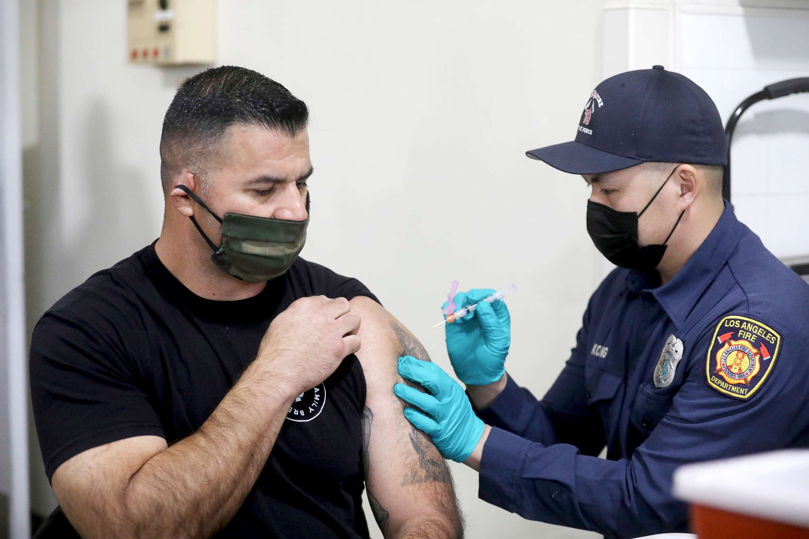 PHOTO: Los Angeles Fire Department Capt. Elliot Ibanez receives the Moderna COVID-19 vaccine given by LAFD paramedic Anthony Kong at Station 4 in Los Angeles, Dec. 28, 2020.