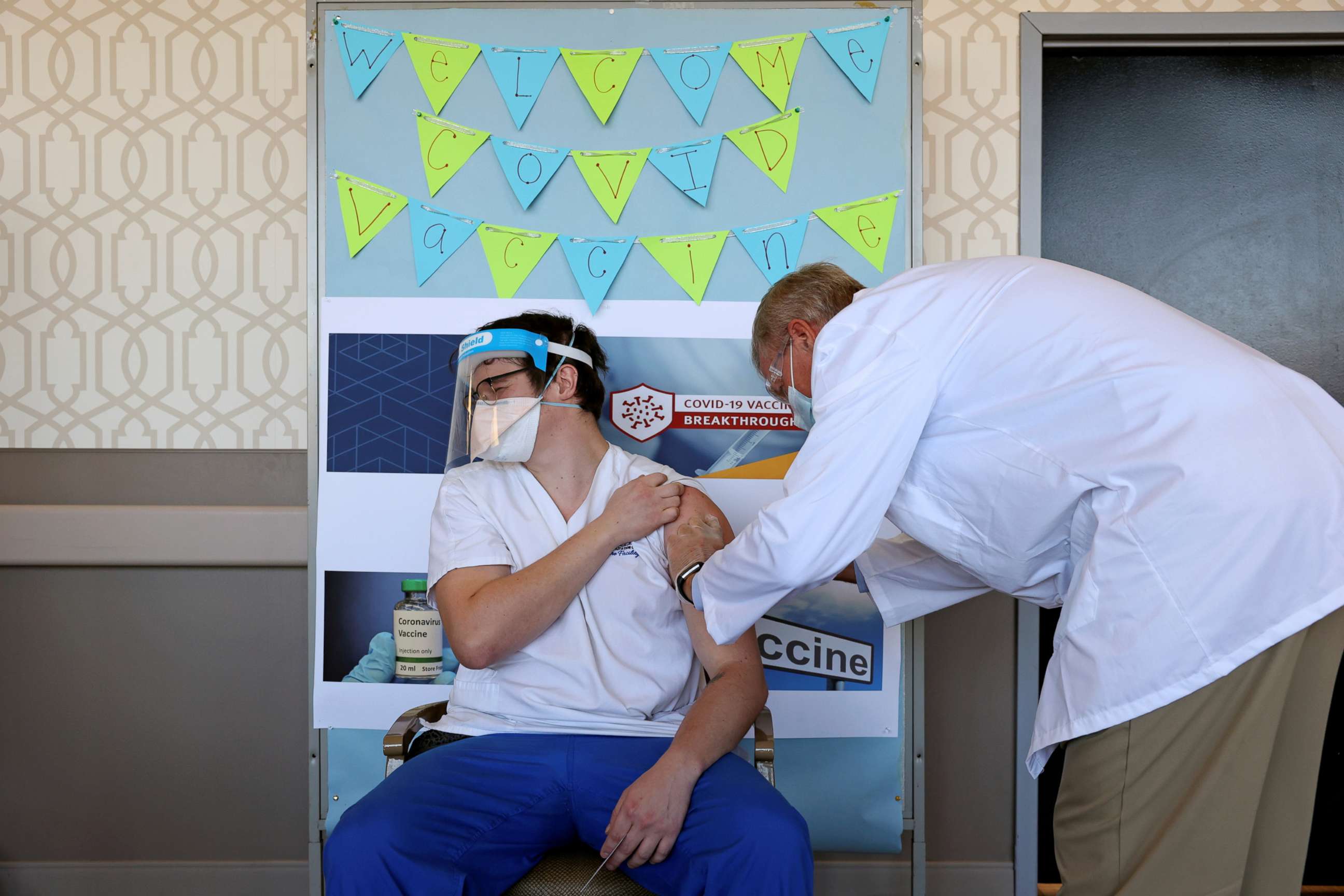 PHOTO: A staff member at Hamilton Park Nursing and Rehabilitation, a nursing home facility, receives the Pfizer-BioNTech COVID-19 vaccine from Walgreens Pharmacist Craig Brandt in Brooklyn, N.Y., Jan. 4, 2021.