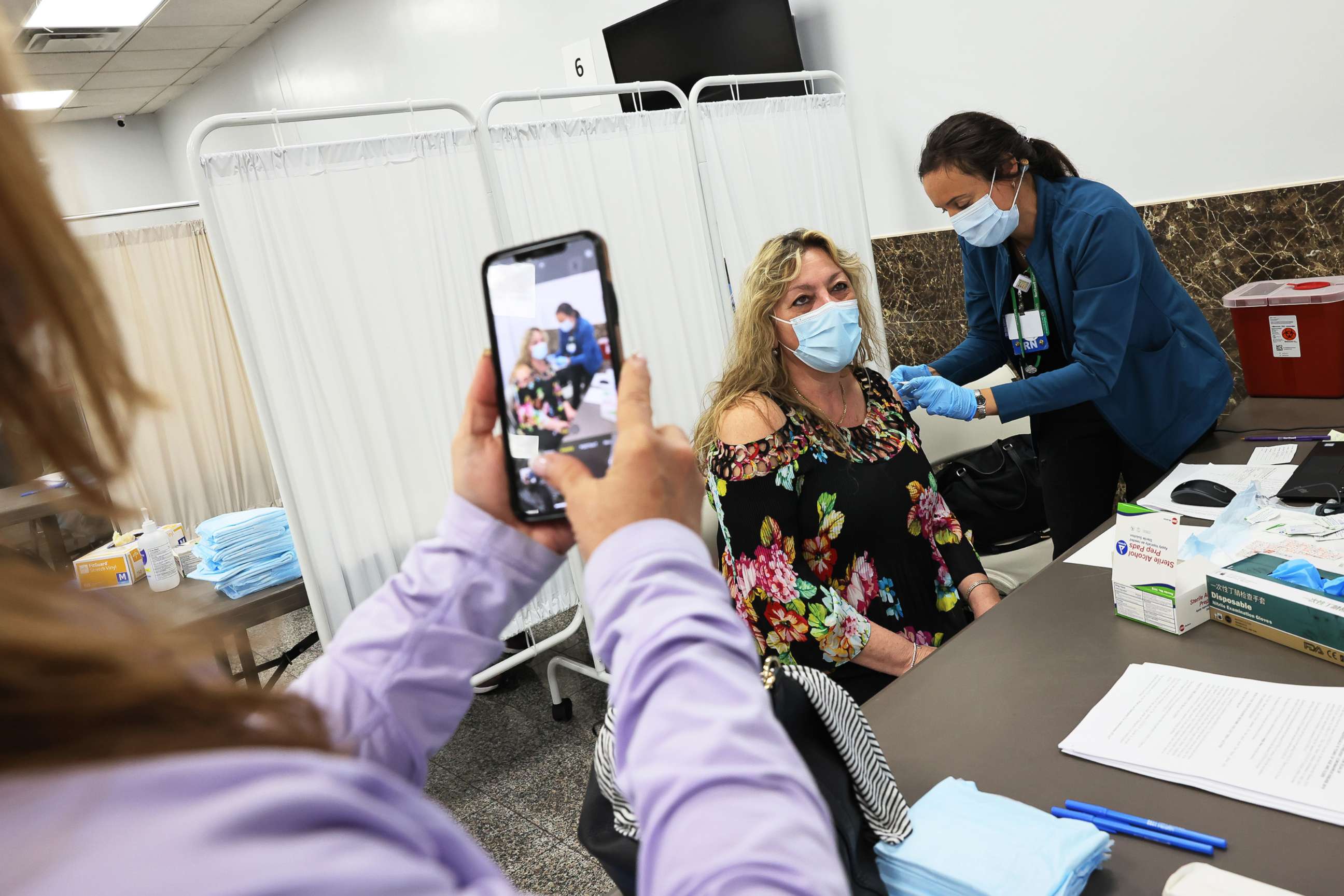 PHOTO: Mara Bianco takes a photo of Dawn Casale as she receives the Johnson & Johnson COVID-19 vaccine at the Northwell Health pop-up vaccination site at the Albanian Islamic Cultural Center in Staten Island on April 08, 2021, in New York City.
