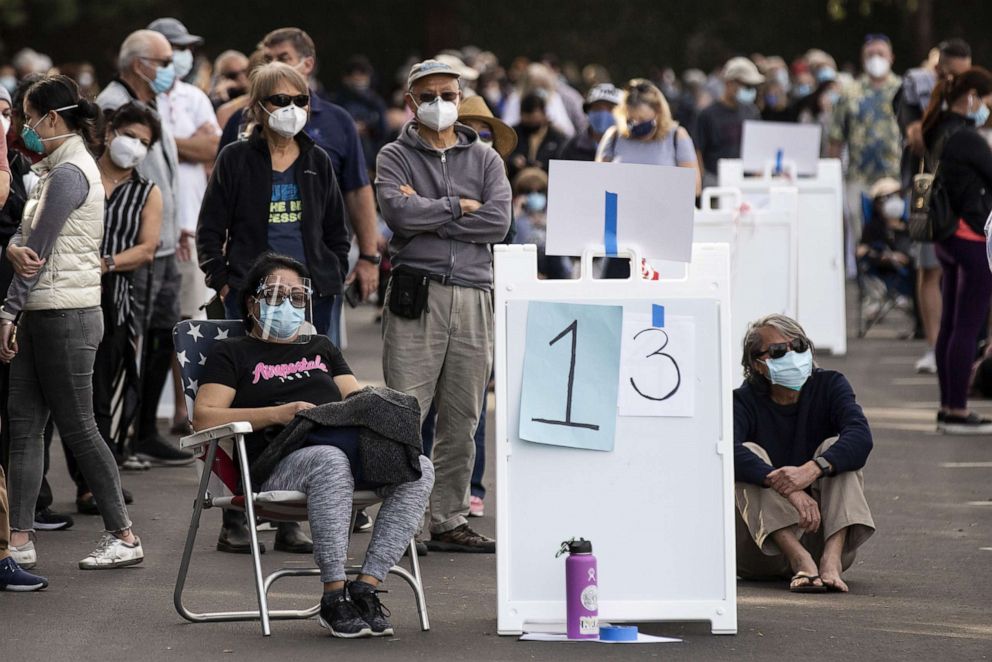 PHOTO: People wait to get vaccinated against COVID-19 in a parking lot at Disneyland in Anaheim, Calif., Jan. 13, 2021.