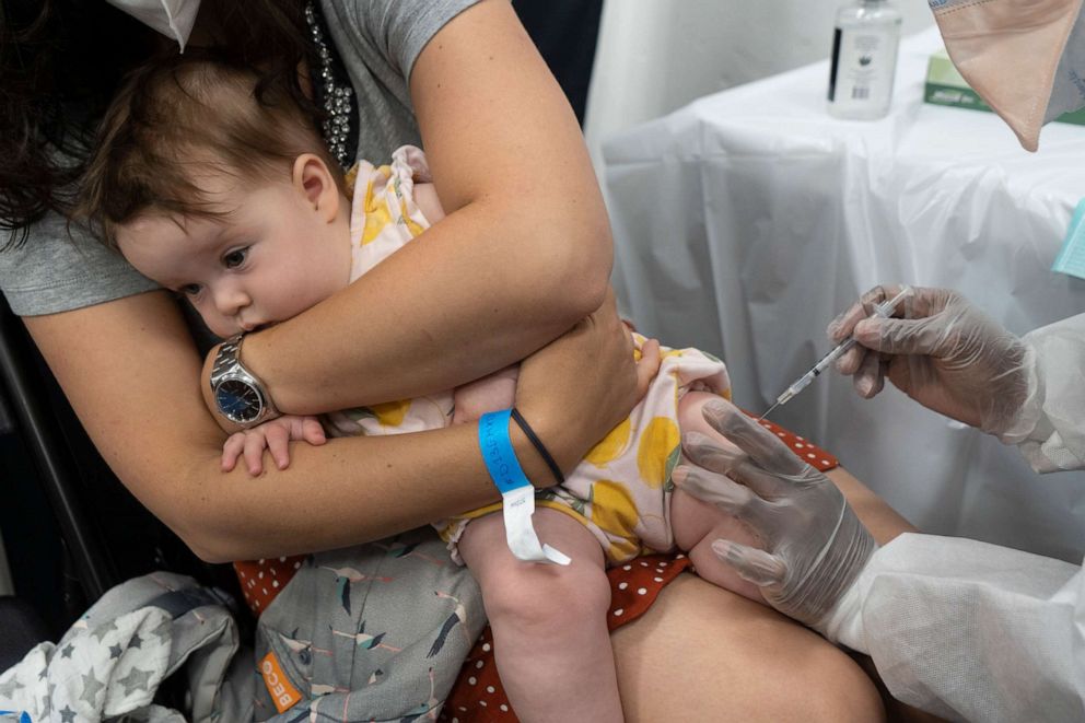 PHOTO: A mother holds her 6-month-old daughter as she receives her first dose of the Moderna vaccine in New York, June 27, 2022.