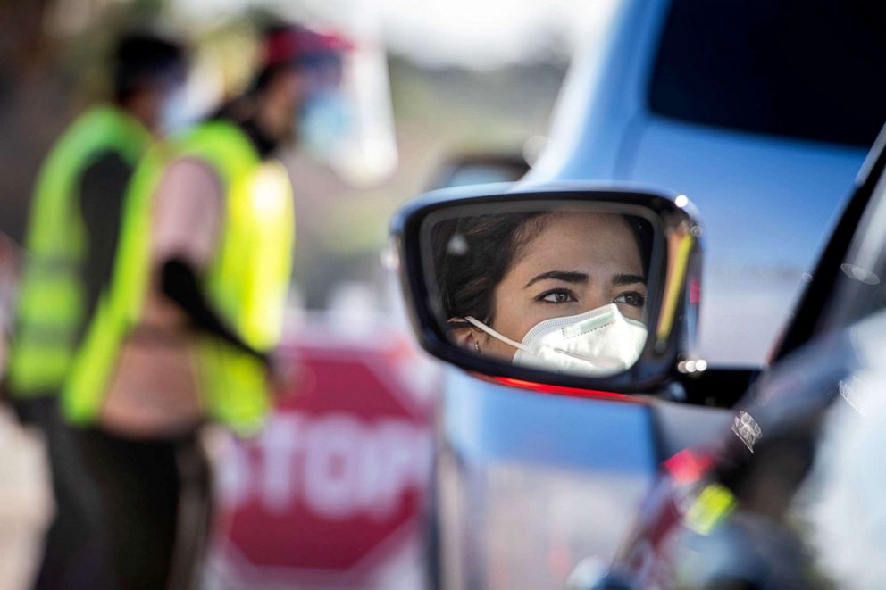 PHOTO: People wait in line for vaccines at Dodger Stadium in Los Angeles after it was turned into a COVID-19 drive-thru vaccination site., Jan. 15, 2021. 