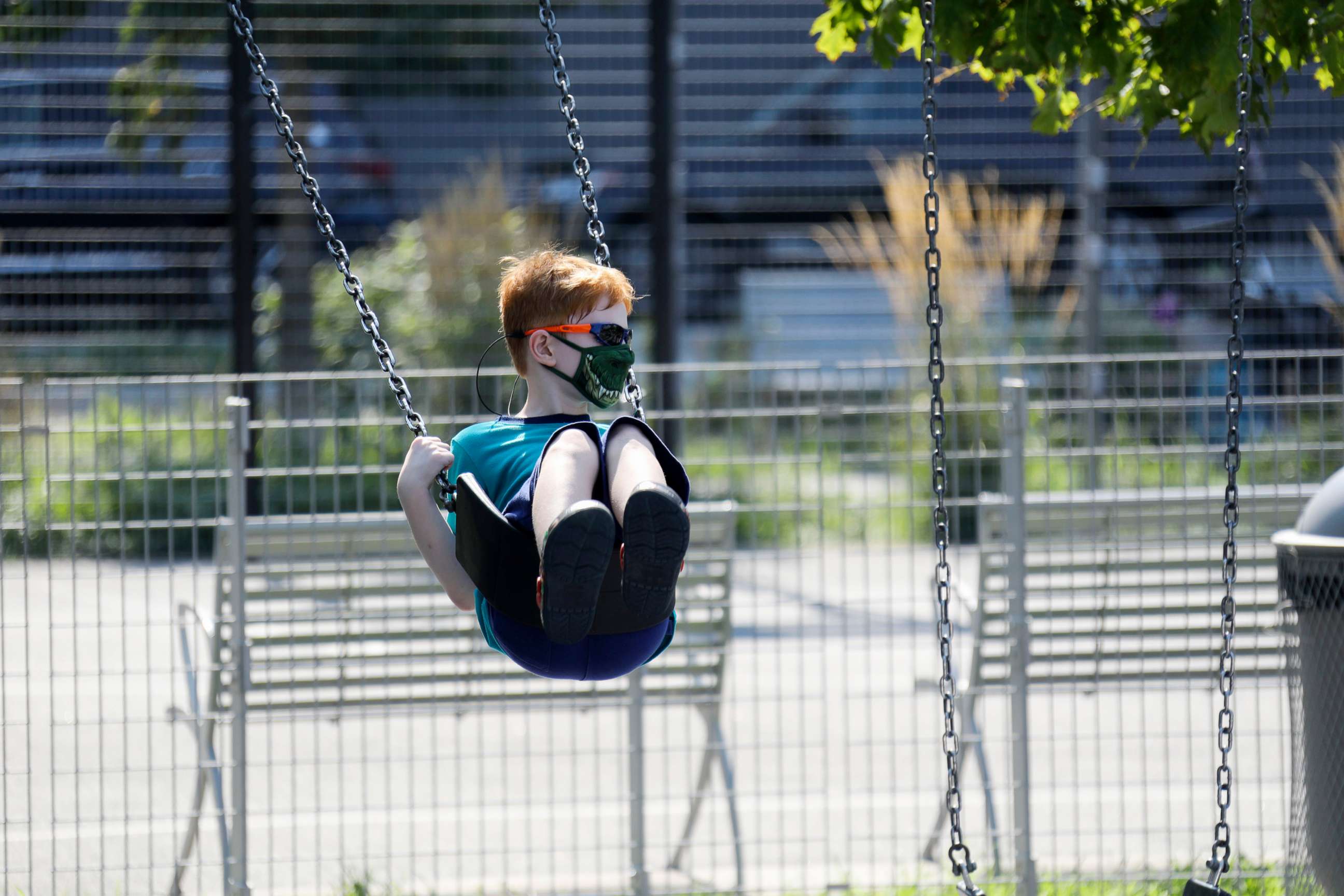 PHOTO: A boy wearing a face mask plays on a swing at a playground in New York, Aug. 9, 2020. 