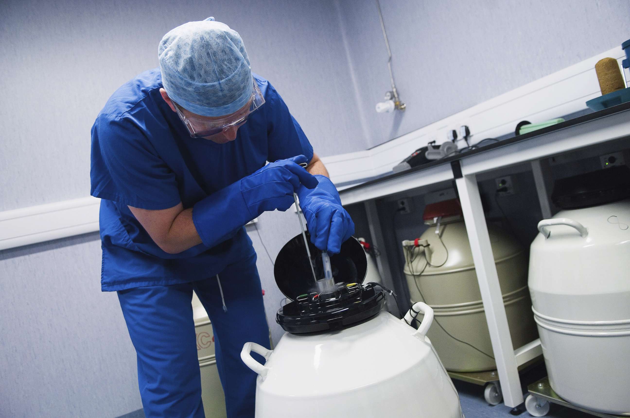 PHOTO: Doctor removing embryo samples from cryogenic storage, Fertilized embryos are stored in liquid nitrogen filled tanks to keep them as new if patients require them at a later date. 