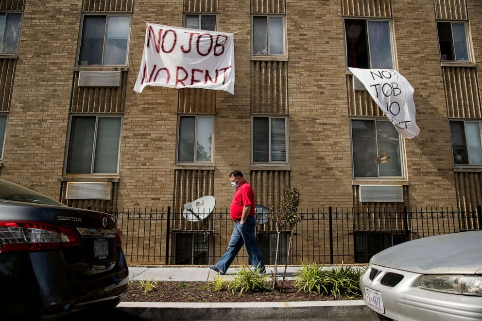 PHOTO: Signs that read "No Job No Rent" hang from the windows of an apartment building in Northwest Washington, May 20, 2020.