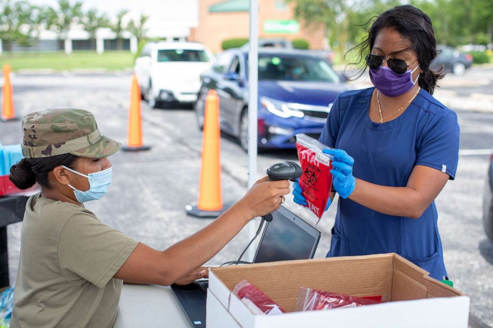 PHOTO: U.S. Army Pfc. Stephanie Huertas, with the Delaware Army National Guard, scans a barcode at a drive-thru testing site for COVID-19 at Delaware Technical Community College in Georgetown, Del., July 16, 2020.