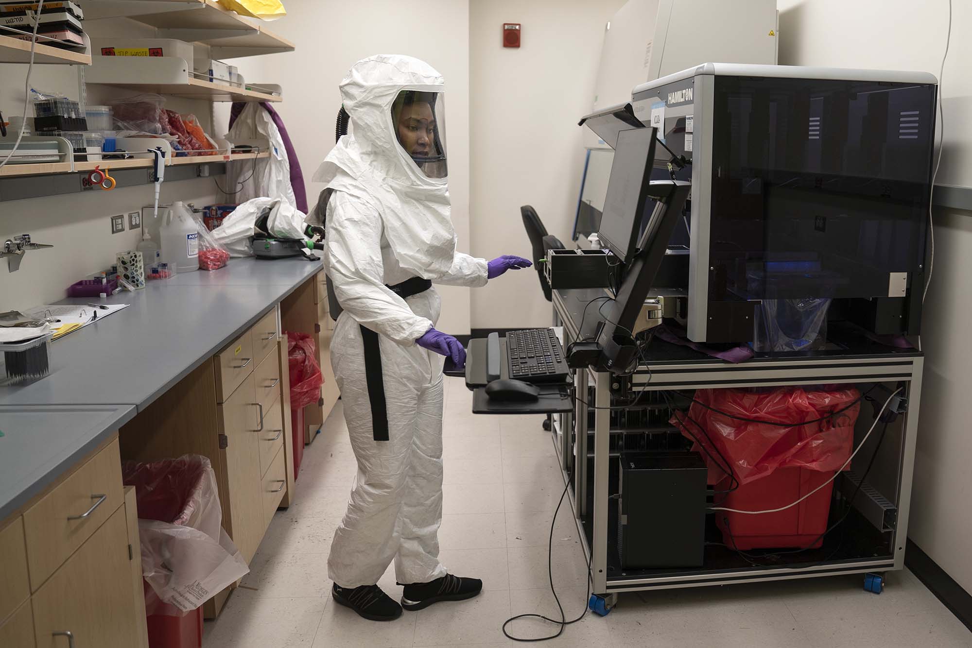 PHOTO: Lab Assistant Tammy Brown dons PPE in a lab where she works on preparing positive Covid tests for sequencing to discern variants that are rapidly spreading throughout the United States in Baltimore, April 9, 2021.