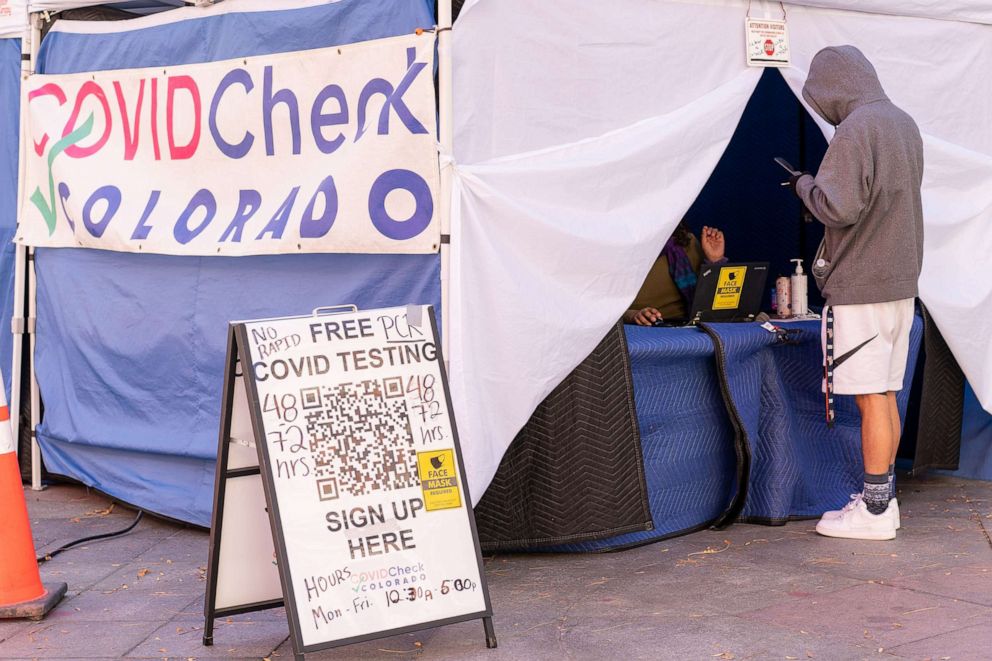 PHOTO: A person stands outside a tent offering free COVID-19 tests in downtown Denver, Nov. 4, 2021.