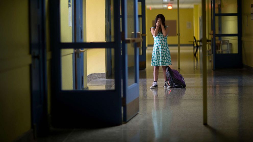 PHOTO: An undated stock photo of a girl in an empty school hallway.