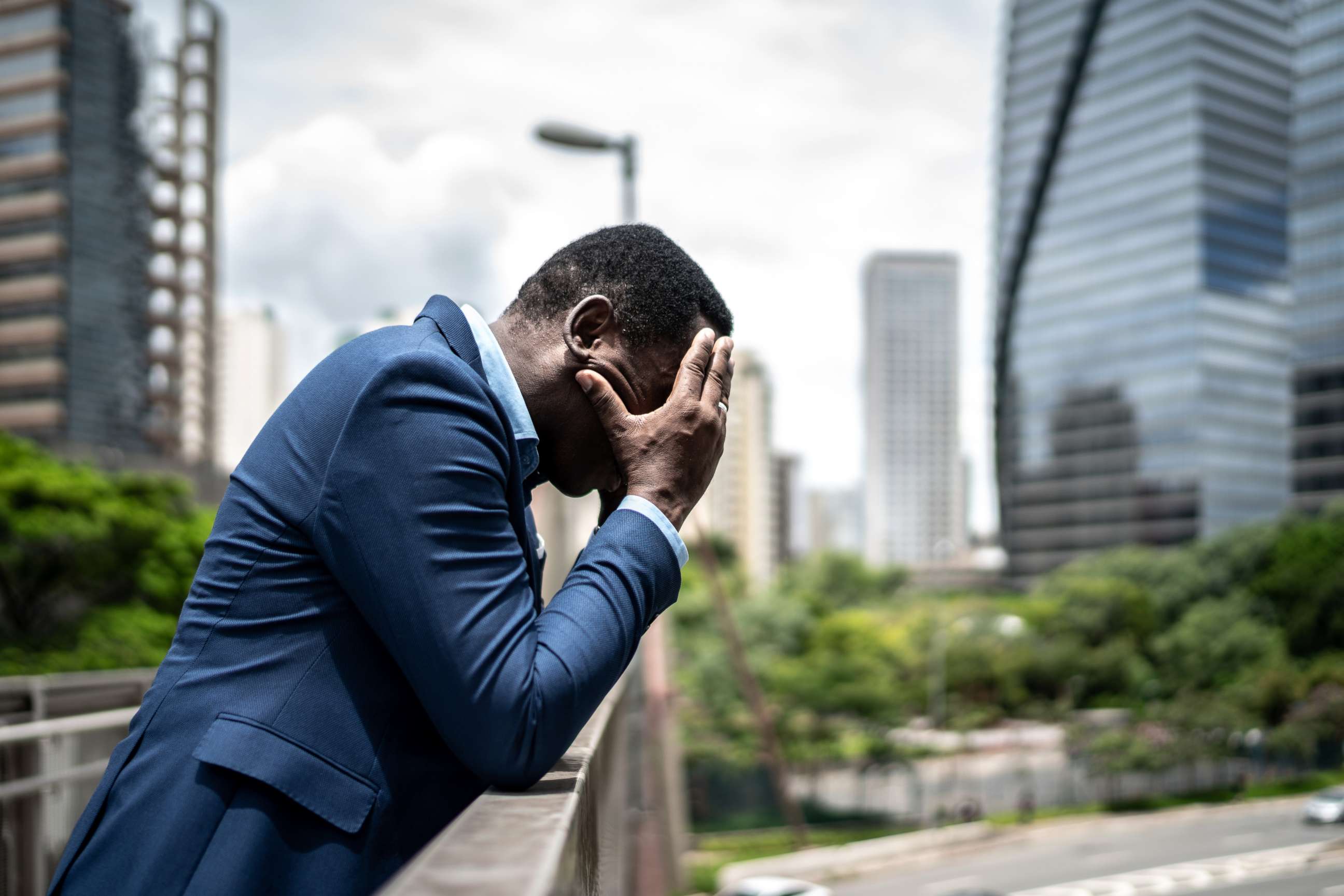 PHOTO: A man cries into his hands on a bridge in this stock photo.