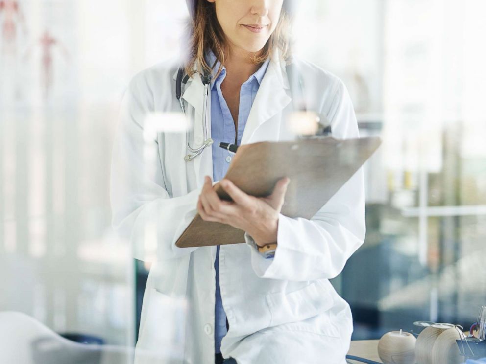 PHOTO: A doctor writes on a clipboard in a consulting room in this undated stock photo.