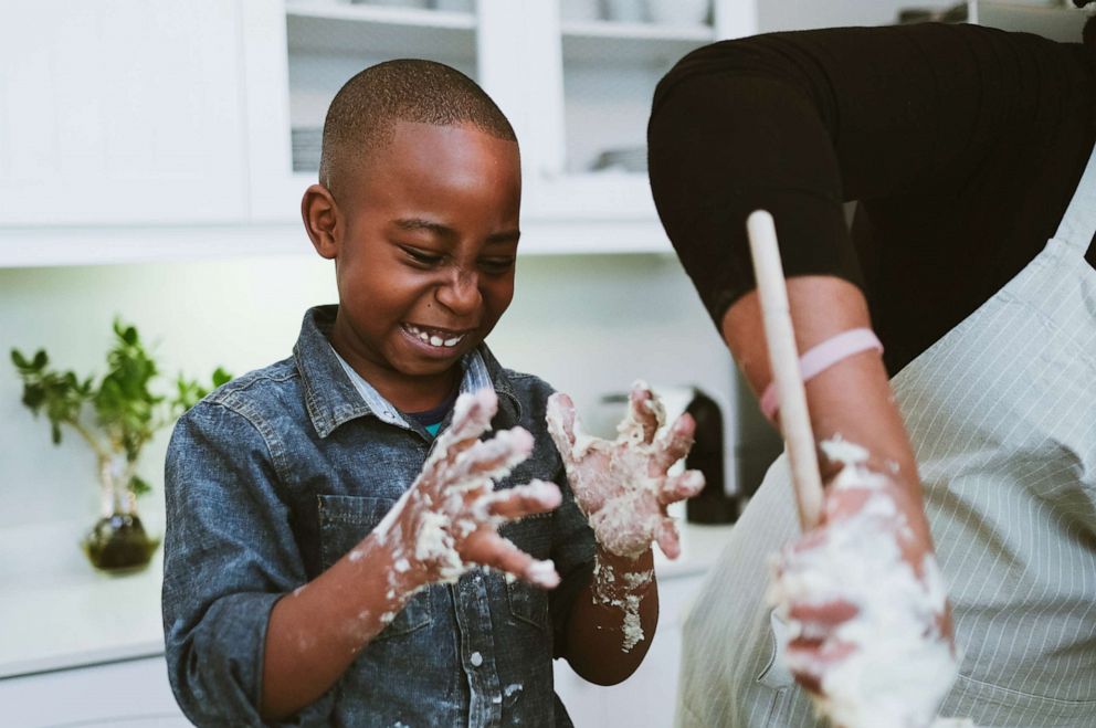 PHOTO: A boy looks reacts to sticky dough while baking.