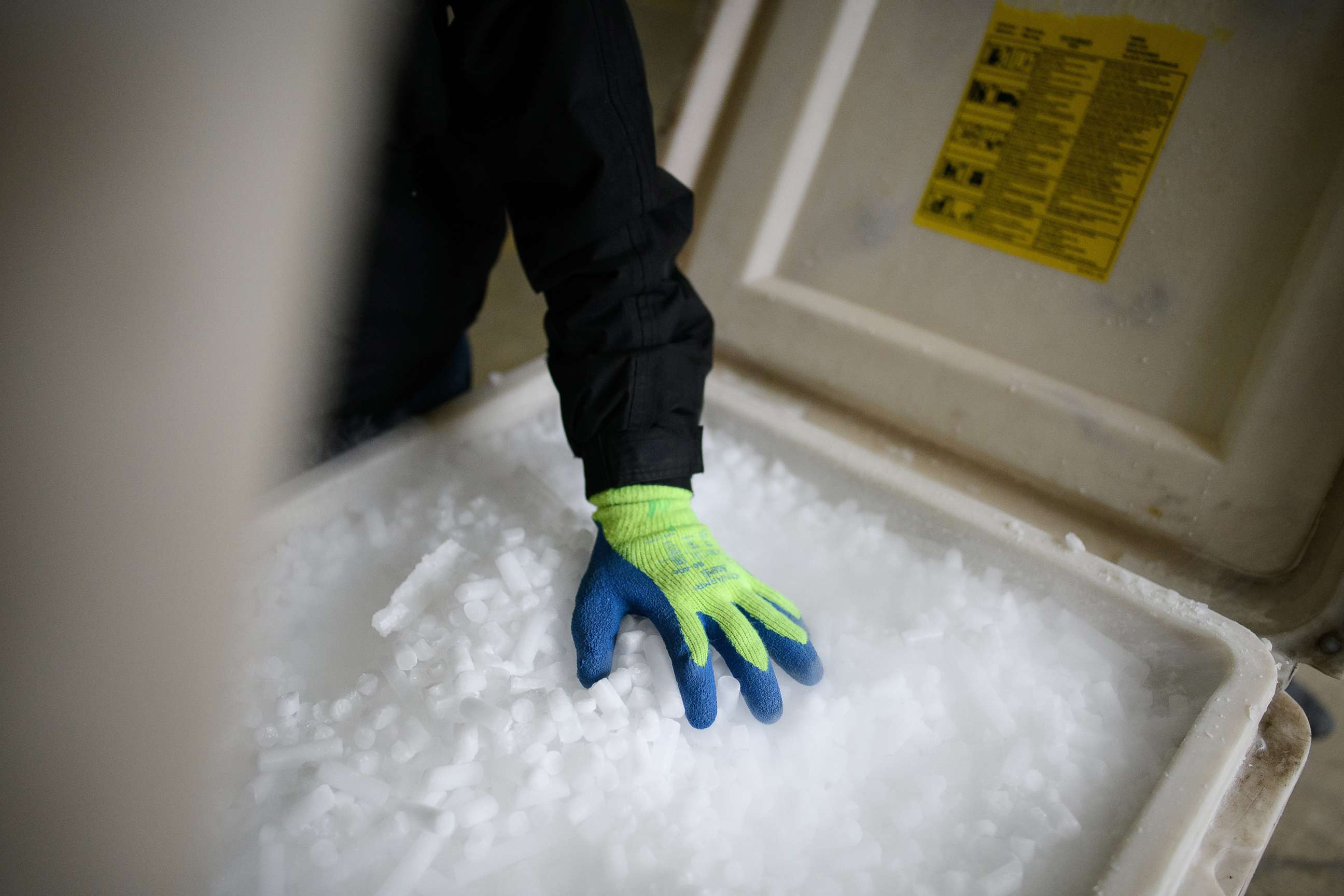 PHOTO: A man shows a fresh supply of coarse dry ice pellets at the Dry Ice Nationwide manufacturing facility, Nov. 11, 2020 in Reading, England.