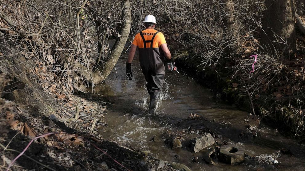 PHOTO: A member of the Environmental Protection Agency (EPA) takes water samples from Sulphur Run creek following a train derailment, Feb. 23, 2022, in East Palestine, Ohio.