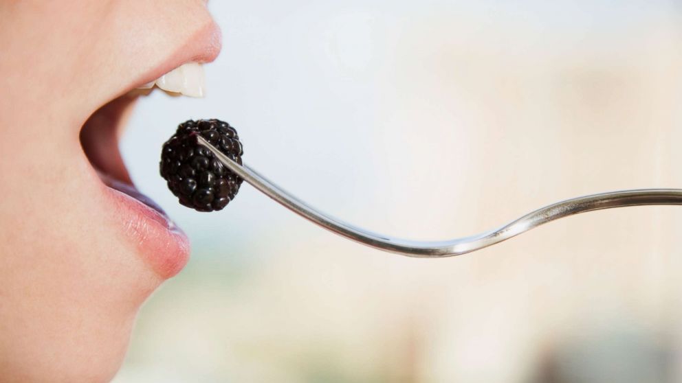 A woman eats a blackberry in an undated stock photo.