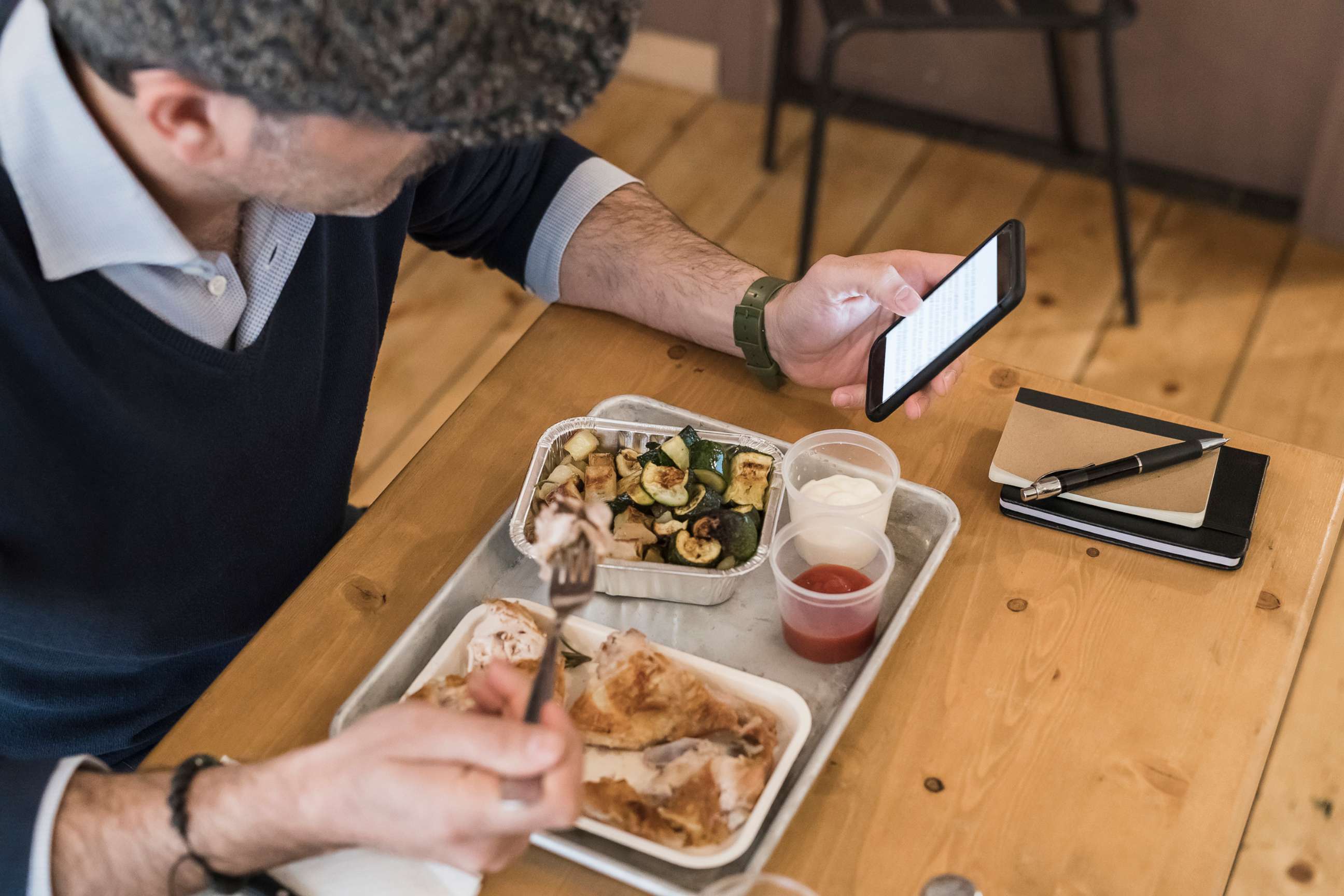 PHOTO: An undated stock photo shows a person holding a smart phone while eating.