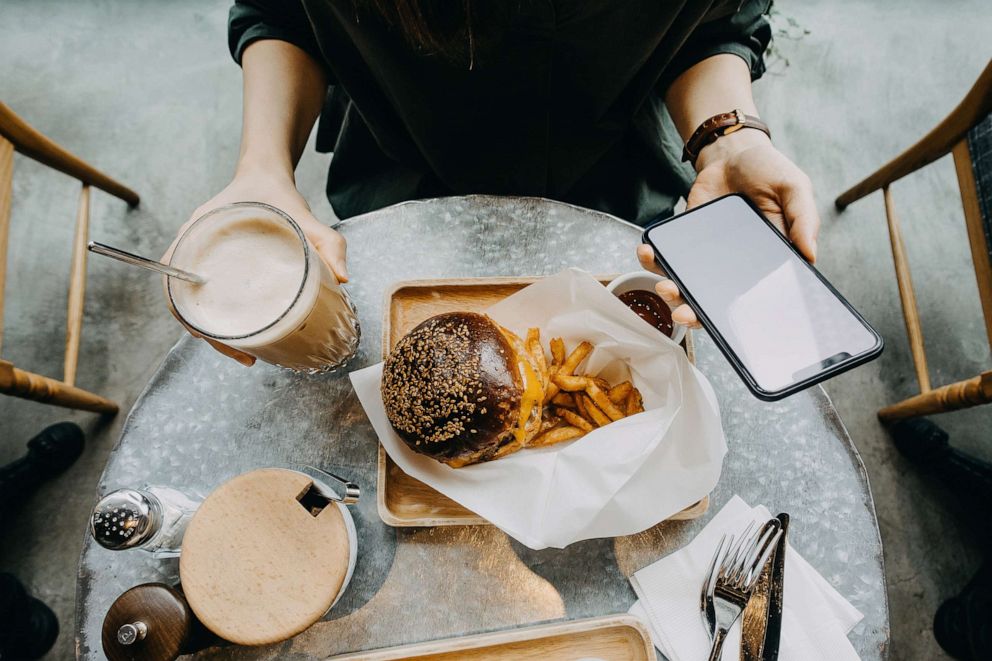 PHOTO: An undated stock photo shows a person holding a smart phone while eating.