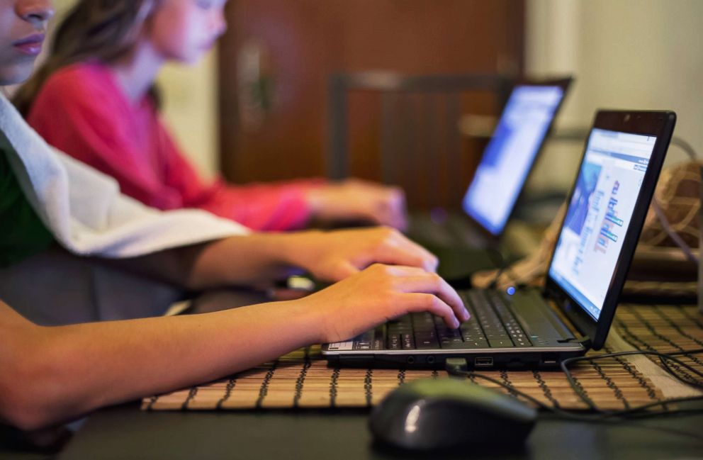 PHOTO: Girls using laptops in the classroom. 