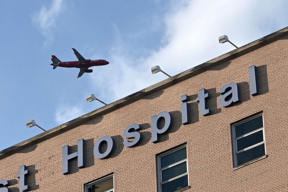 PHOTO: In a tribute to frontline health care workers during the COVID-19 pandemic, a JetBlue passenger plane flies over NYC Health + Hospital/Elmhurst just before 7:00 pm, in Queens, N.Y, May 7, 2020.