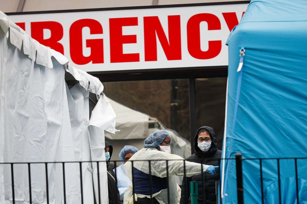 PHOTO: A medical worker directs a patient to enter a COVID-19 testing site at Elmhurst Hospital Center, Wednesday, March 25, 2020, in New York. 