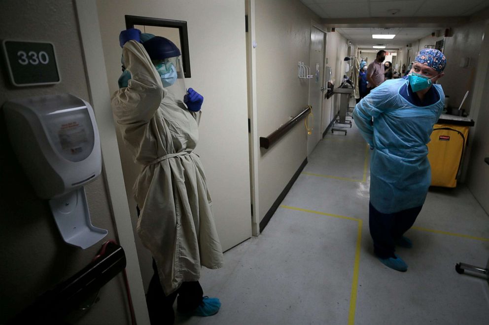 PHOTO: Nursing assistant Angelica Corral, left, and nurse  Daniel Corral constantly change their PPE as they travel from room to room at the El Paso LTAC Hospital in El Paso, Texas, Nov., 6, 2020.
