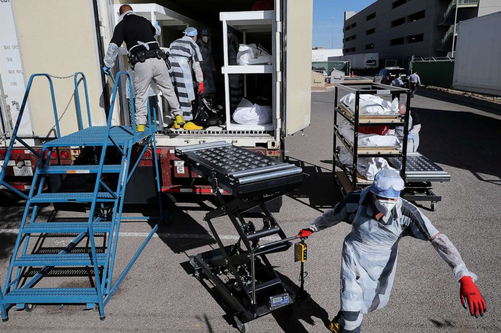 PHOTO: Inmates from El Paso County detention facility work loading bodies into a refrigerated temporary morgue trailer in a parking lot of the El Paso County Medical Examiner's office, Nov. 17, 2020 in El Paso, Texas.