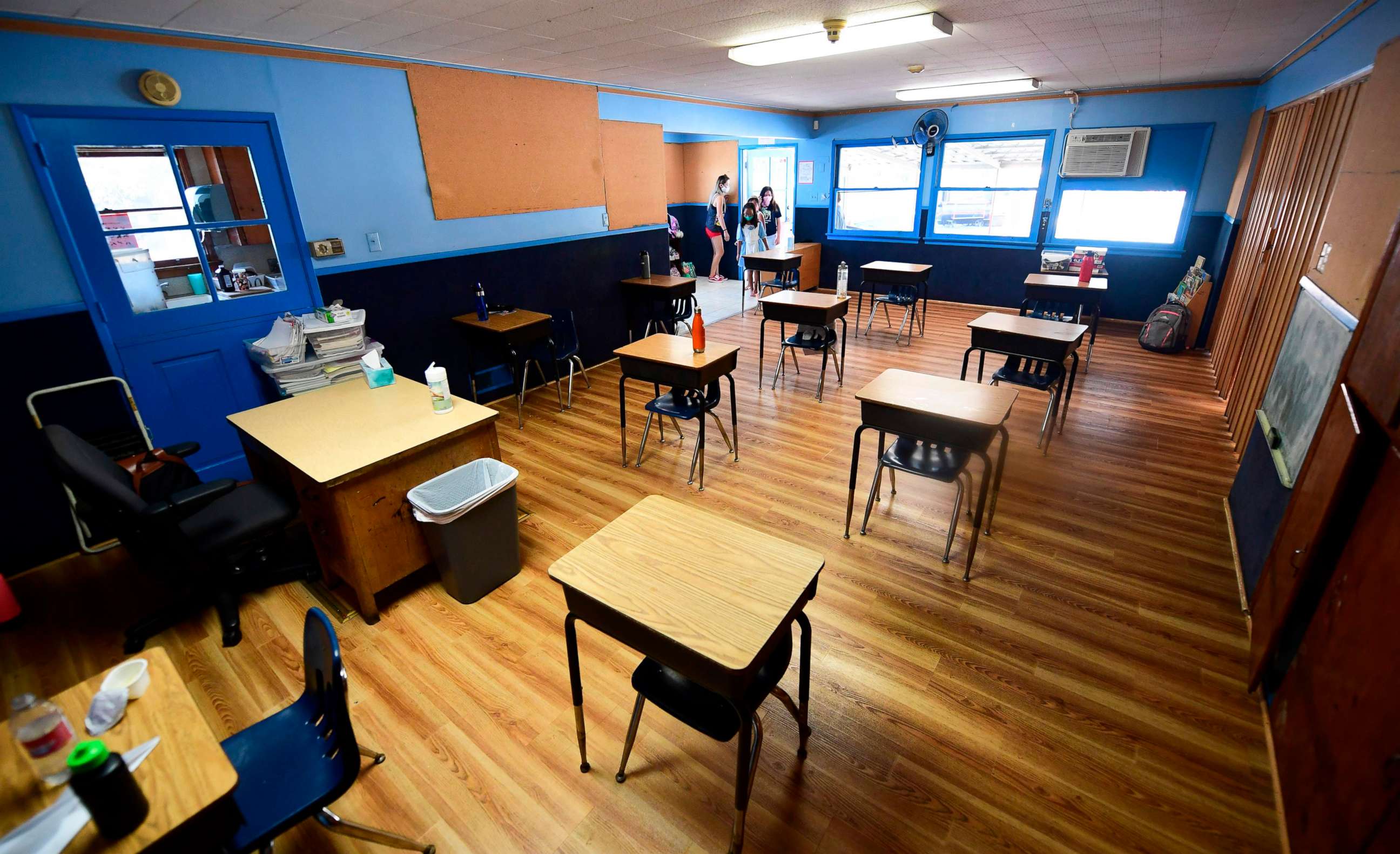 PHOTO: Children, wearing masks, enter a classroom with desks spaced apart, as per coronavirus guidelines, during summer school sessions in Monterey Park, Calif., July 9, 2020.