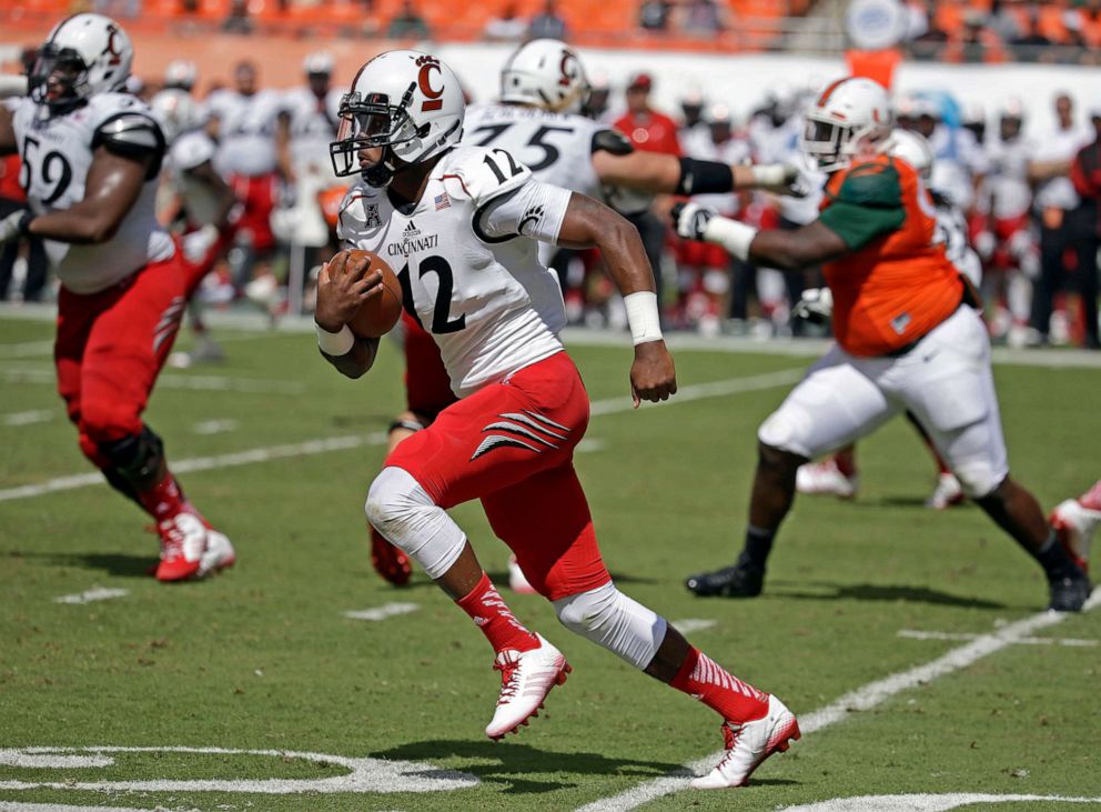 PHOTO: Cincinnati quarterback Jarred Evans (12) runs in the second half of an NCAA college football game against Miami in Miami Gardens, Fla., Oct. 11, 2014.