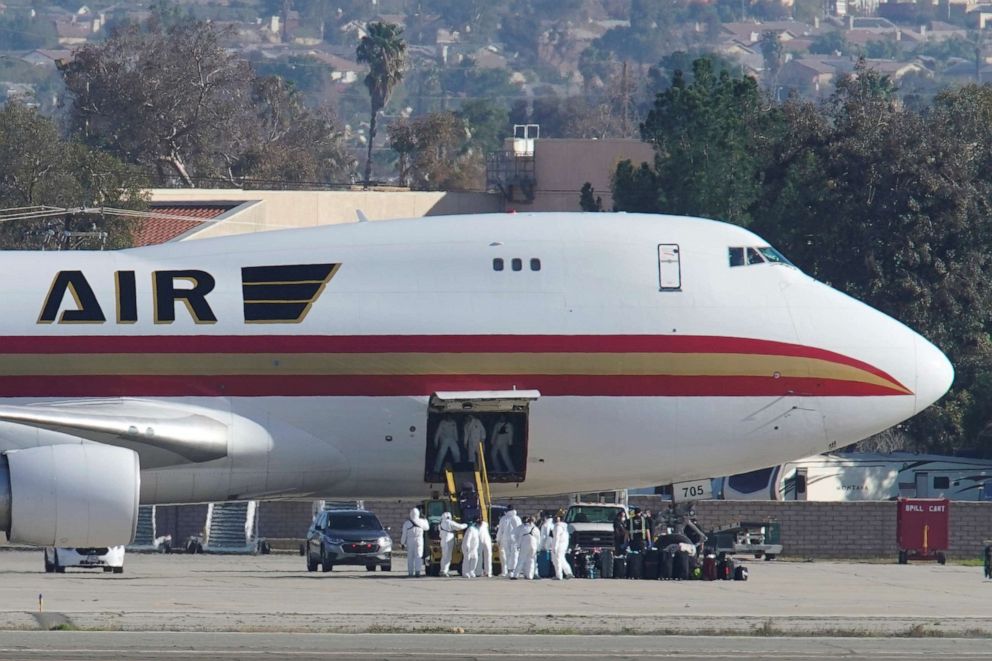 PHOTO: Personnel in protective clothing approach an aircraft to evacuate Americans from the coronavirus threat in the Chinese city of Wuhan, after it arrived at March Air Reserve Base in Riverside County, Calif., Jan. 29, 2020. 