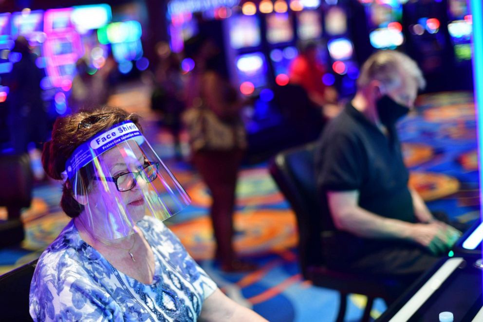 PHOTO: A woman wearing a face shield gambles at Ocean Casino after it reopened on July 3, 2020, in Atlantic City, N.J.