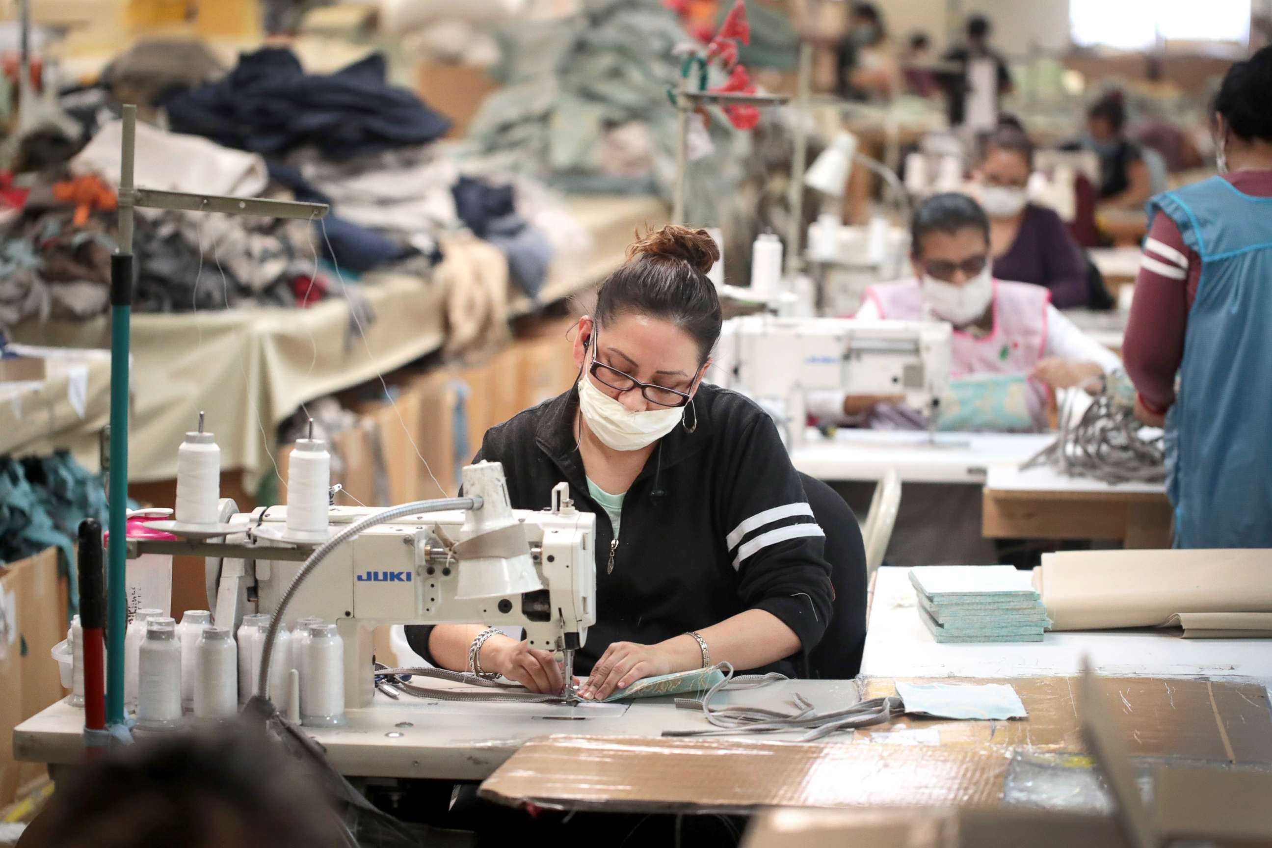 PHOTO: Workers sew personal protective equipment (PPE) at an outdoor furniture manufacturer in Alsip, Ill., March 30, 2020.