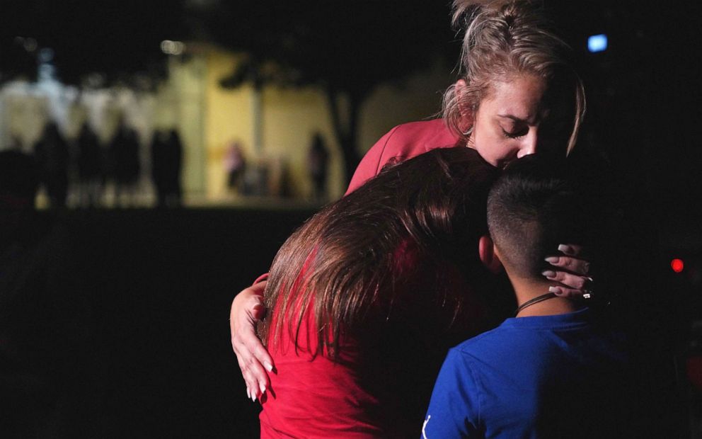 PHOTO: Families hug outside the Staff Sgt. Willie de Leon Civic Center where grief counseling is offered, in Uvalde, Texas, May 24, 2022, following a mass shooting at Robb Elementary School.