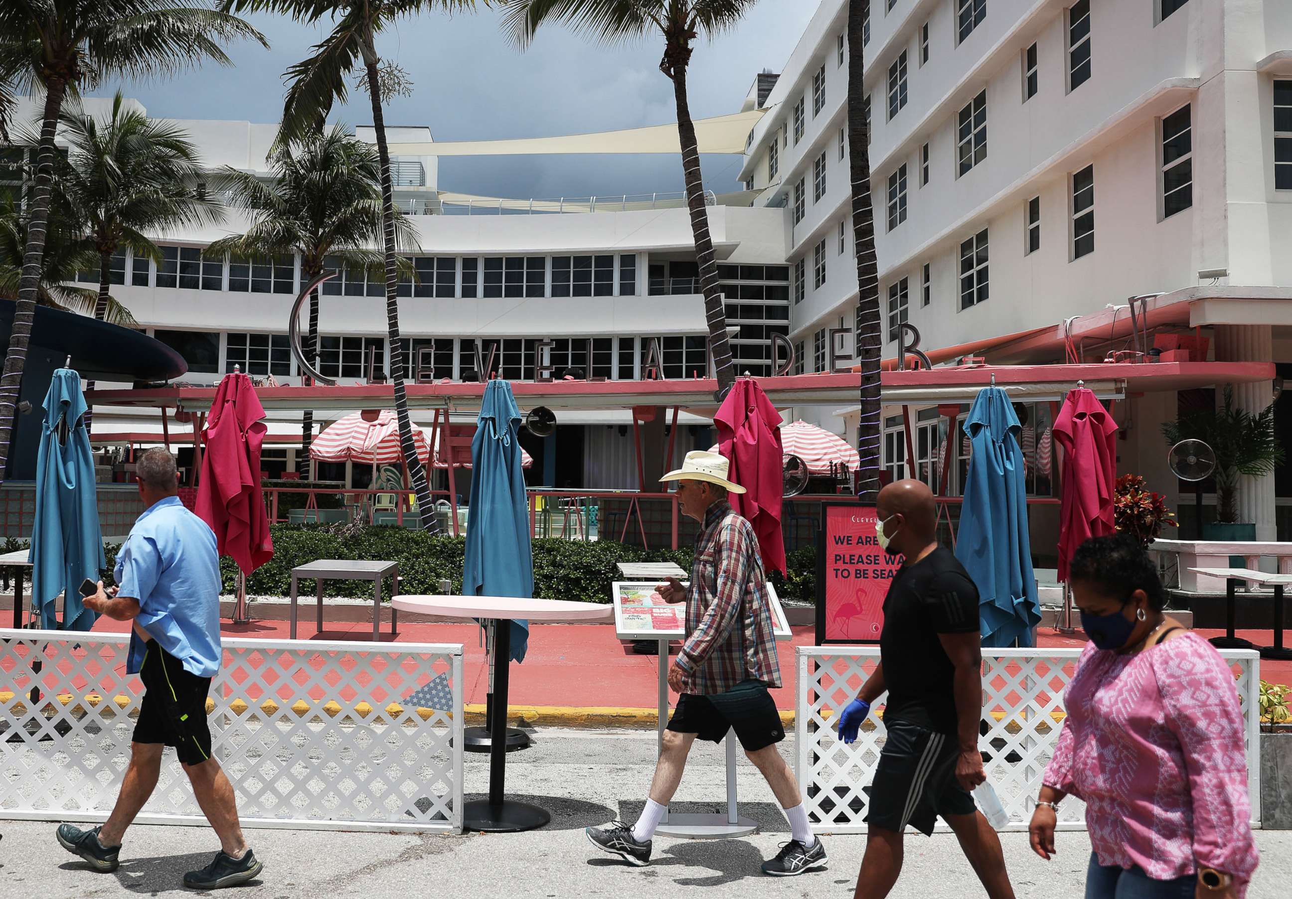 PHOTO: People walk past the Clevelander South Beach Hotel on July 13, 2020, in Miami Beach, Fla. The hotel announced it was closing again until further notice due to growing concerns about the Covid-19 pandemic in Miami-Dade County.
