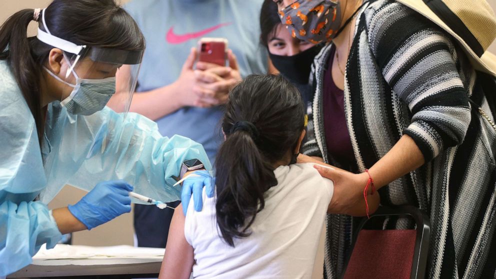 PHOTO: A child receives the flu vaccination shot from a nurse at a free clinic held at a local library on Oct. 14, 2020 in Lakewood, Calif.