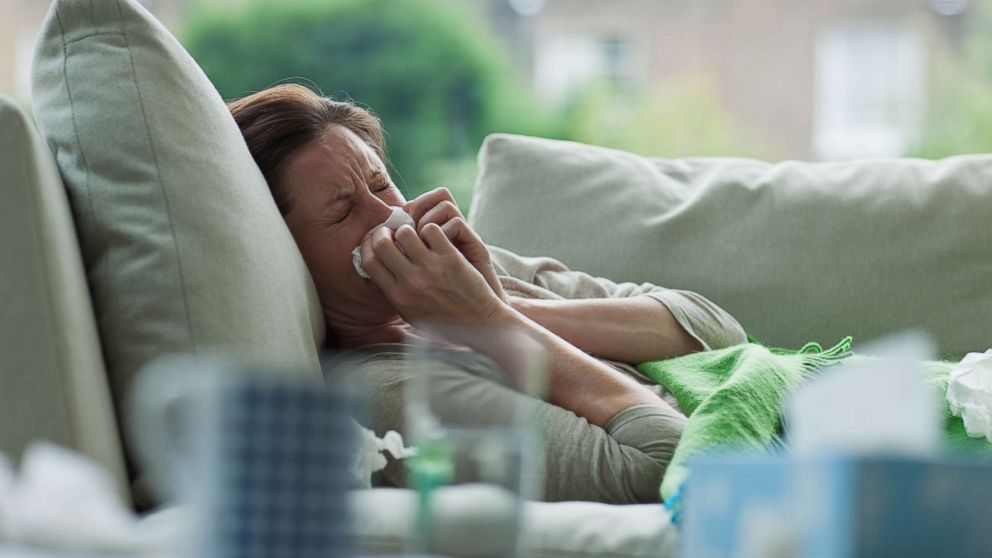 A woman blows her nose in an undated stock photo. 