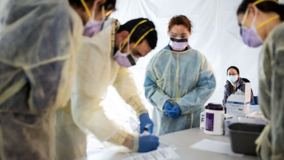PHOTO: FILE - Doctors test hospital staff with flu-like symptoms for coronavirus (COVID-19) in set-up tents outside before they enter the main Emergency department area at St. Barnabas hospital in the Bronx, March 24, 2020 in New York City. 